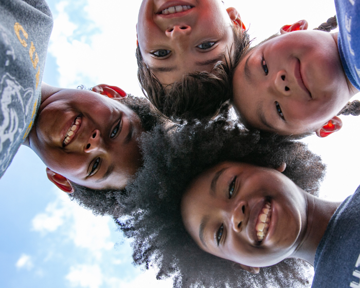 Children smiling down into camera